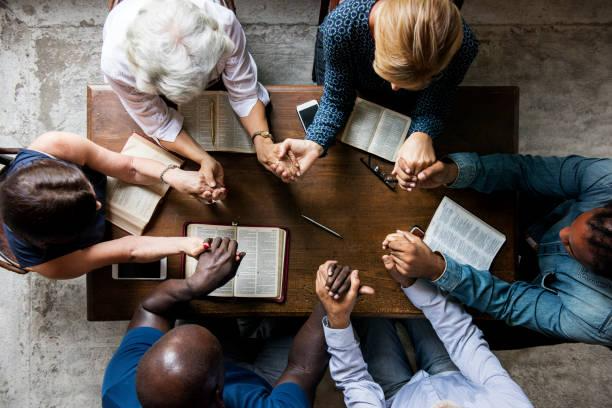 Group in bible study holding hands